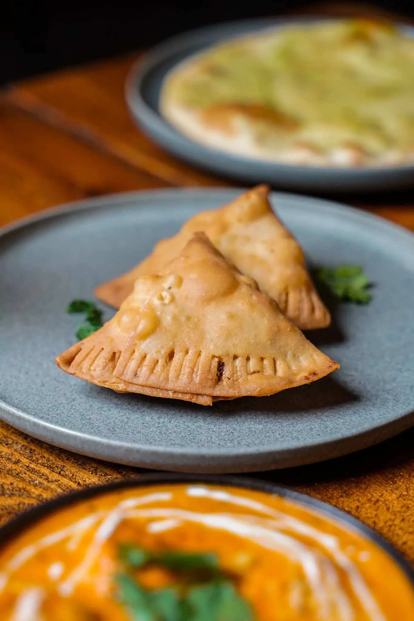 Sprød samosa serveret med frisk koriander